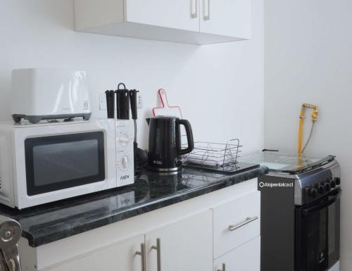 a kitchen counter top with a microwave and a microwave at Casa completa 3D 2B, amplia comoda y equipada in Talca