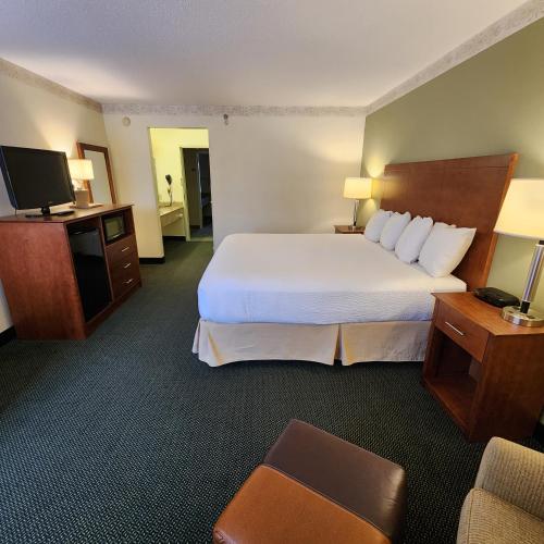 a hotel room with a large bed and a television at Baymont by Wyndham Mackinaw City in Mackinaw City