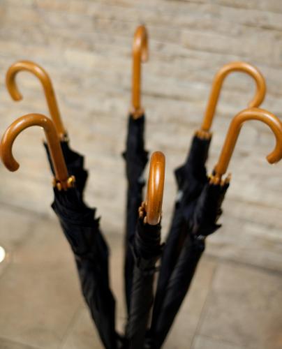 a group of two black umbrellas with wooden handles at CORTIINA Hotel in Munich