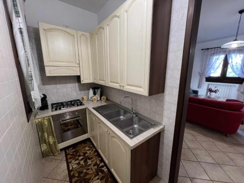 uma pequena cozinha com armários brancos e um lavatório em Villa Sole by TripOstuni em San Vito dei Normanni
