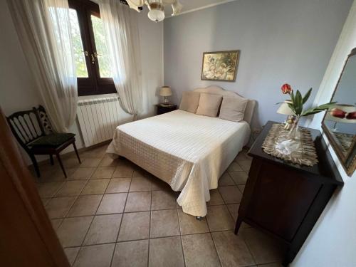 een slaapkamer met een bed, een stoel en een tafel bij Villa Sole by TripOstuni in San Vito dei Normanni