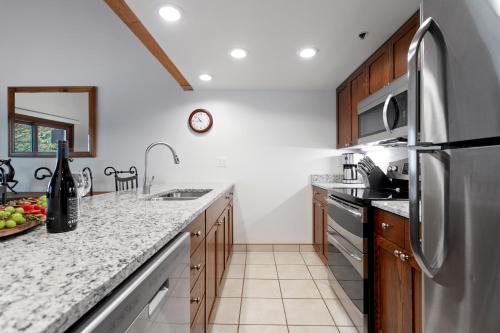 eine Küche mit einem Kühlschrank und Schränken aus Edelstahl in der Unterkunft Deer Valley's Signature Collection in Park City