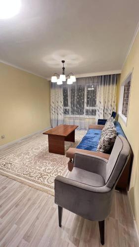 a bedroom with a bed and a desk in a room at 3 комнатная квартира Бесагаш Сити in Almaty