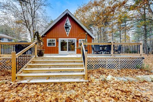 a small red house with a wooden porch and stairs at Crescent Corner in Waterboro