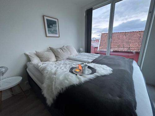 a bedroom with a large bed with a tray on it at Stylish Coastal House with Stunning Ocean View in Borhaug