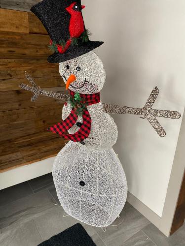a snowman with a cardinal on top of it at Chalet Le Shack in Stratford