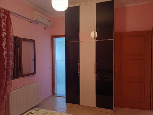 une grande armoire noire dans une pièce avec porte dans l'établissement Leonidas Apartment, à Berat