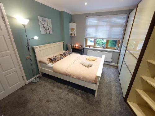 um pequeno quarto com uma cama e uma janela em Lovely room with ensuite in a quiet house em Rayleigh