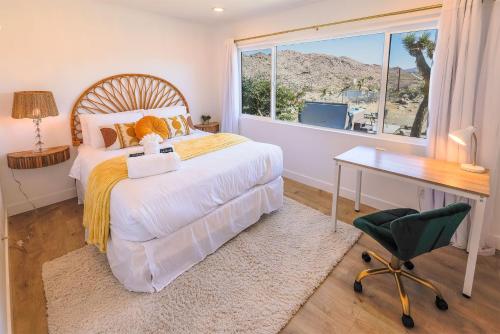 a bedroom with a bed and a desk and a window at New: Dome, Hot Tub, Game Room, 5 min to park in Joshua Tree
