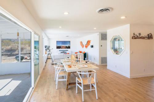 a dining room and living room with a table and chairs at New: Dome, Hot Tub, Game Room, 5 min to park in Joshua Tree