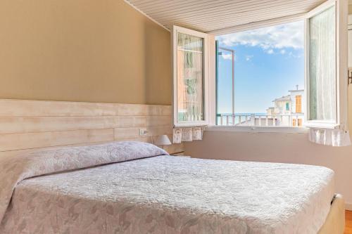 sypialnia z łóżkiem i dużym oknem w obiekcie Alla Marina Affittacamere w mieście Riomaggiore