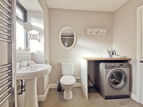 a bathroom with a sink and a washing machine at TULLOCHSIDE-4 BED-SEA FRONT -RAVENSPOINT ROAD in Trearddur
