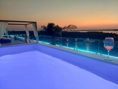 a bed and a glass of wine on a balcony at The View - Adults Only Resort in Pipa