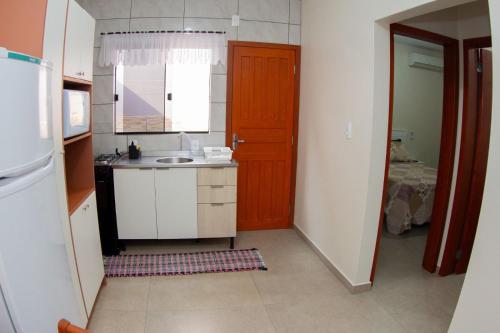 a small kitchen with a sink and a door at Apartamento encantador próximo praia mercado Farm padaria in Imbituba