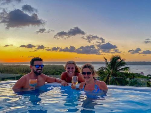 three people in a swimming pool with glasses of wine at The View - Adults Only Resort in Pipa