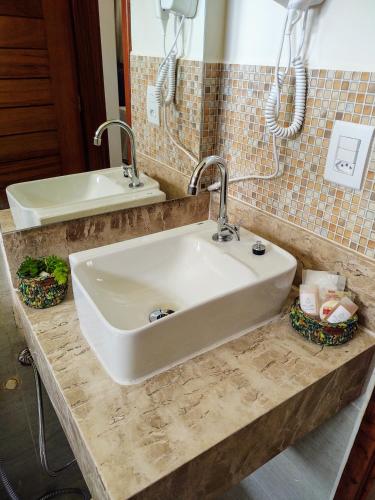 a bathroom with a white sink and a mirror at Kai'ala Pousada in São Miguel do Gostoso