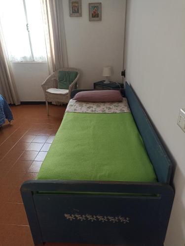 a bed in a room with a green mattress at Cascina Marasca Appartamento Sole in Martina Olba