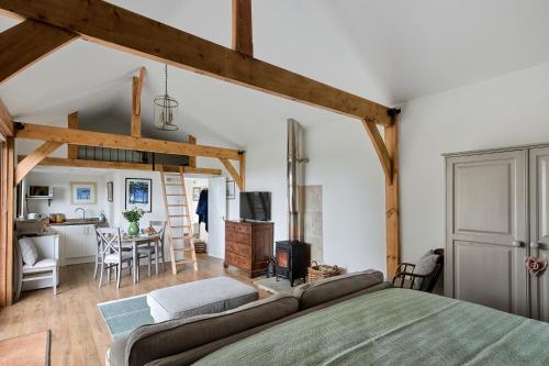 um quarto com uma cama e uma sala de jantar em Stunning Cabin with incredible views near Goodwood em Rogate