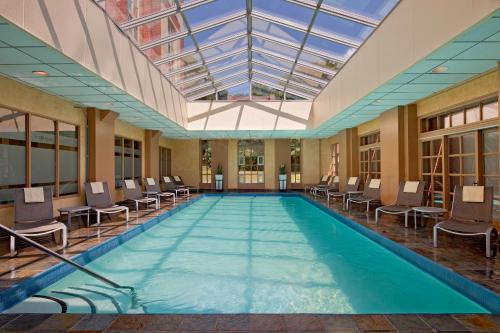 uma grande piscina interior com cadeiras e um tecto em Hyatt Regency Greenwich em Greenwich