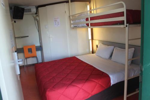 a bedroom with a bunk bed with a red blanket at Hôtel Premiere Classe Pamiers in Pamiers