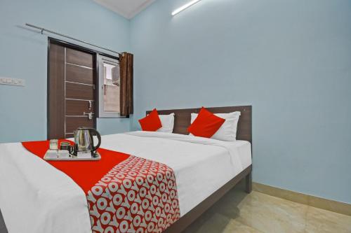 1 dormitorio con 1 cama grande con almohadas rojas en Flagship Hotel Ansh Plaza en Jaipur