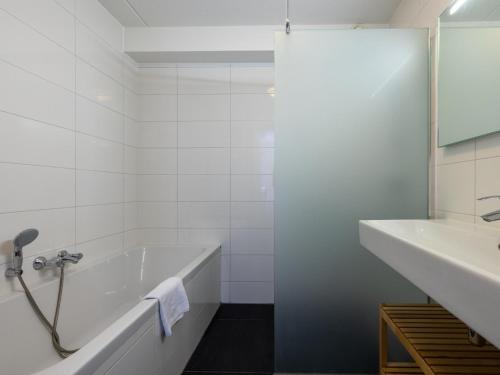 ein weißes Badezimmer mit einer Badewanne und einem Waschbecken in der Unterkunft Great Assum in Uitgeest