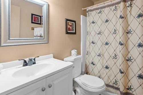 a bathroom with a sink and a toilet and a mirror at Black Forest Lodge in Big Bear Lake
