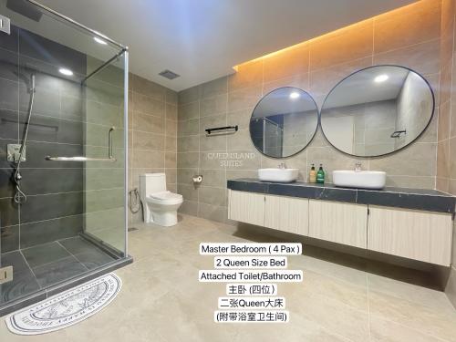 a bathroom with a shower and two sinks and a mirror at QUEENSLAND SUITES at Aru Suites, Kota Kinabalu in Kota Kinabalu
