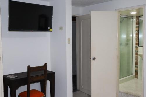比亞維森西奧的住宿－Hotel Inambu，一间房间,墙上有桌子和电视