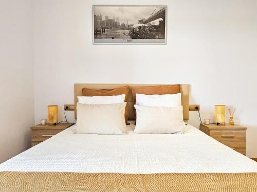 1 dormitorio con 1 cama grande con sábanas y almohadas blancas en Balcón de Añoreta - Alojamientos La Torre en Torre de Benagalbón