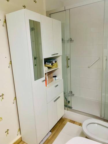 une salle de bain avec toilettes et douche en verre dans l'établissement Vue mer Appartement Le Miramar, à La Baule