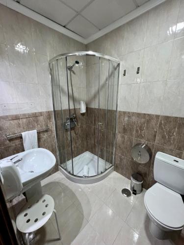 a bathroom with a shower and a toilet and a sink at Hostal Kaizen in La Nucía