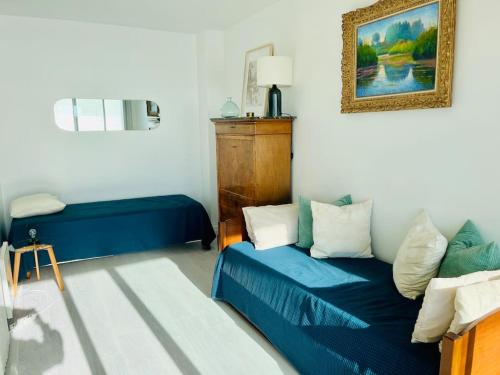 ein Schlafzimmer mit einem blauen Bett und einem Spiegel in der Unterkunft Vue mer Appartement Le Miramar in La Baule