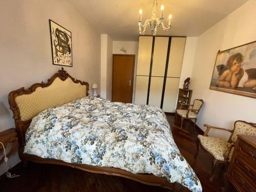 a bedroom with a bed with a floral comforter at Stanza classica Eur Tintoretto in Rome