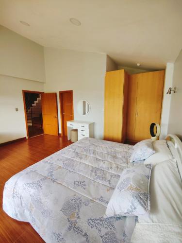 a bedroom with a large bed and wooden floors at Quinta Esperanza in Loja
