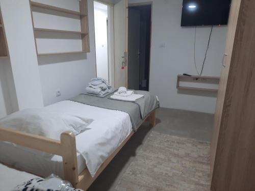two beds in a small room with a television at Kladenče in Pirot