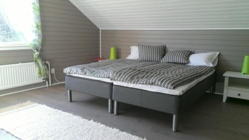 a bed sitting in a room next to a window at Metsäniityn Tuvat in Billnäs