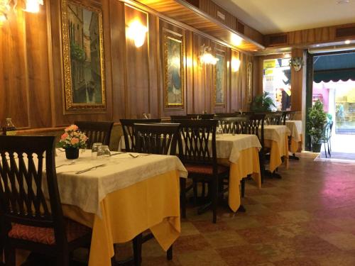 a dining room with tables with yellow table cloths at Antico Panada in Venice