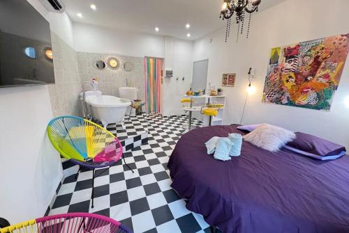 - une chambre avec un lit violet et une salle de bains dans l'établissement La Suite PopArt - Baignoire - Lit Rond, à Marseille