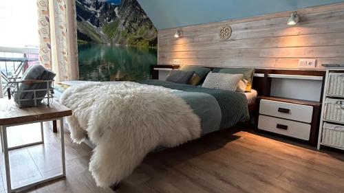 a bedroom with a large bed with a white furry couch at APARTAMENTY Adamcykówka blisko stoku Czorsztyn-Ski! Jacuzzi i Sauna w cenie! in Kluszkowce