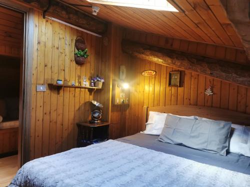 sypialnia z łóżkiem z drewnianą ścianą w obiekcie Pichi's House w mieście Cesuna