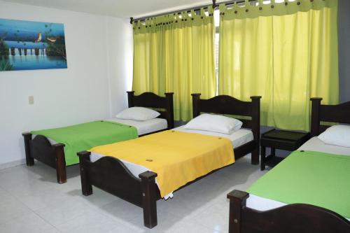 比亞維森西奧的住宿－Hotel Inambu，一间设有三张黄色和绿色床铺的客房