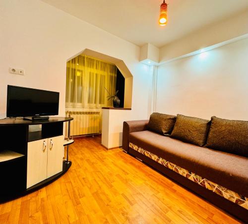 a living room with a couch and a flat screen tv at Altheda Living Eroilor 116-A4 in Suceava