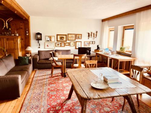 een woonkamer met een bank en een tafel bij B&B Pichler Casa in Castello di Fiemme