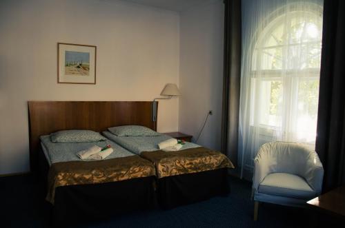 a bedroom with a bed and a chair and a window at ''Zatoka" in Bydgoszcz