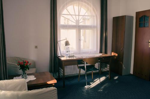 a room with a desk and a window with a laptop at ''Zatoka" in Bydgoszcz