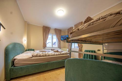 a bedroom with two bunk beds and two chairs at Maison Ostaria MyHolidayLivigno in Livigno