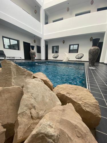 a large swimming pool with rocks in a building at Appartement 1 Riad Dar Samar in Tamraght Ouzdar