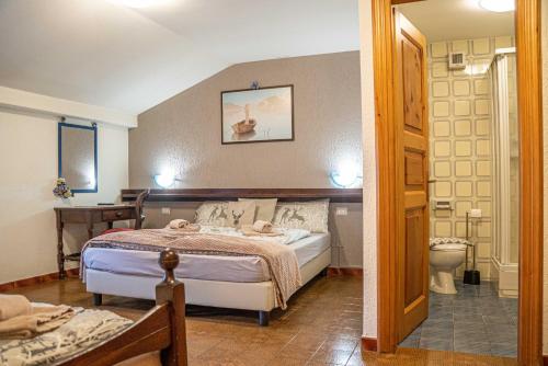 a bedroom with a bed and a bathroom with a toilet at Maison Ostaria MyHolidayLivigno in Livigno