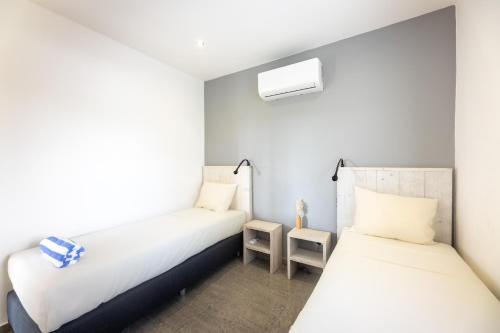 2 camas en una habitación con paredes blancas en Palm Crest, en Willemstad